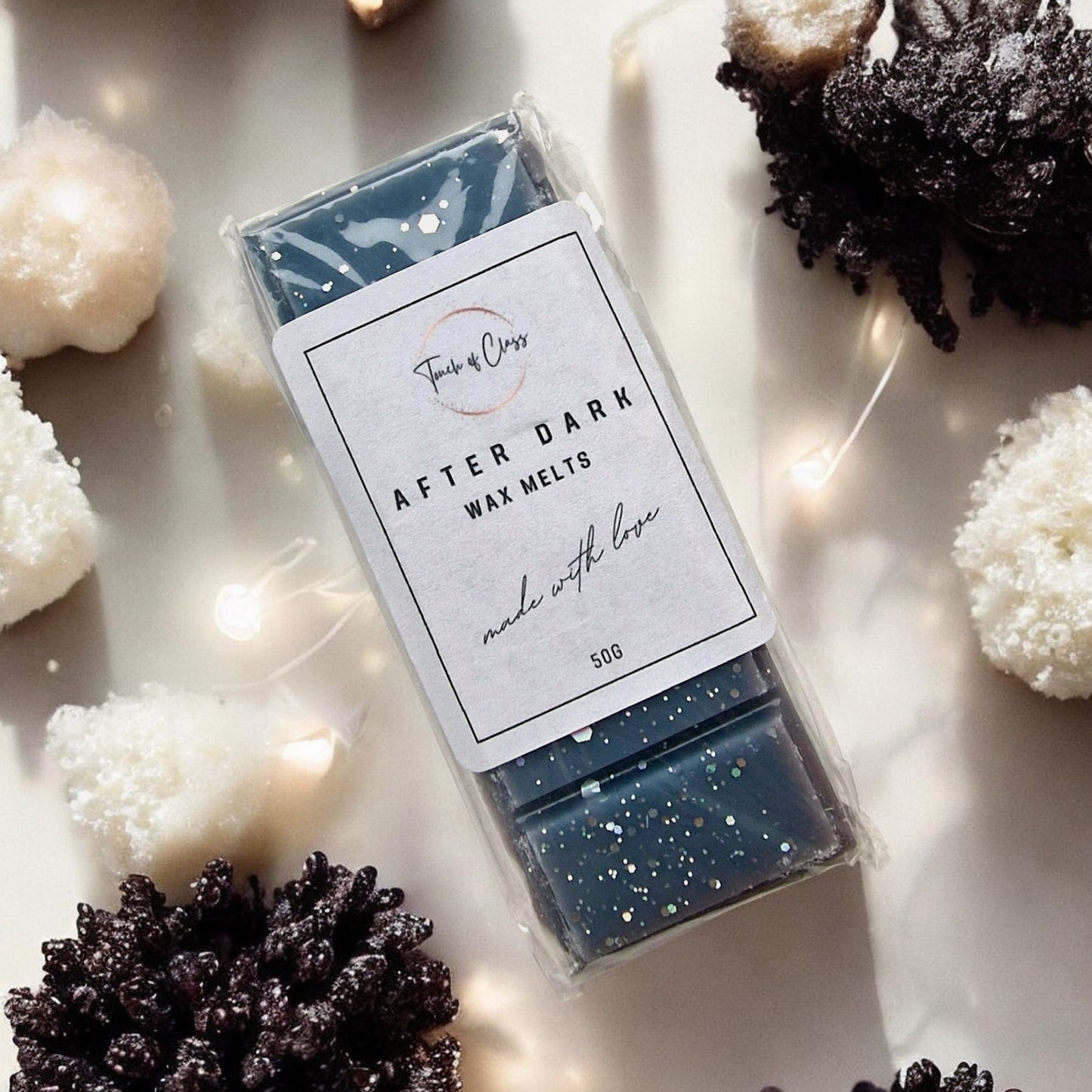 A close up photo of After Dark wax melts by touch of class. The wax melt is in the shape of a snap bar