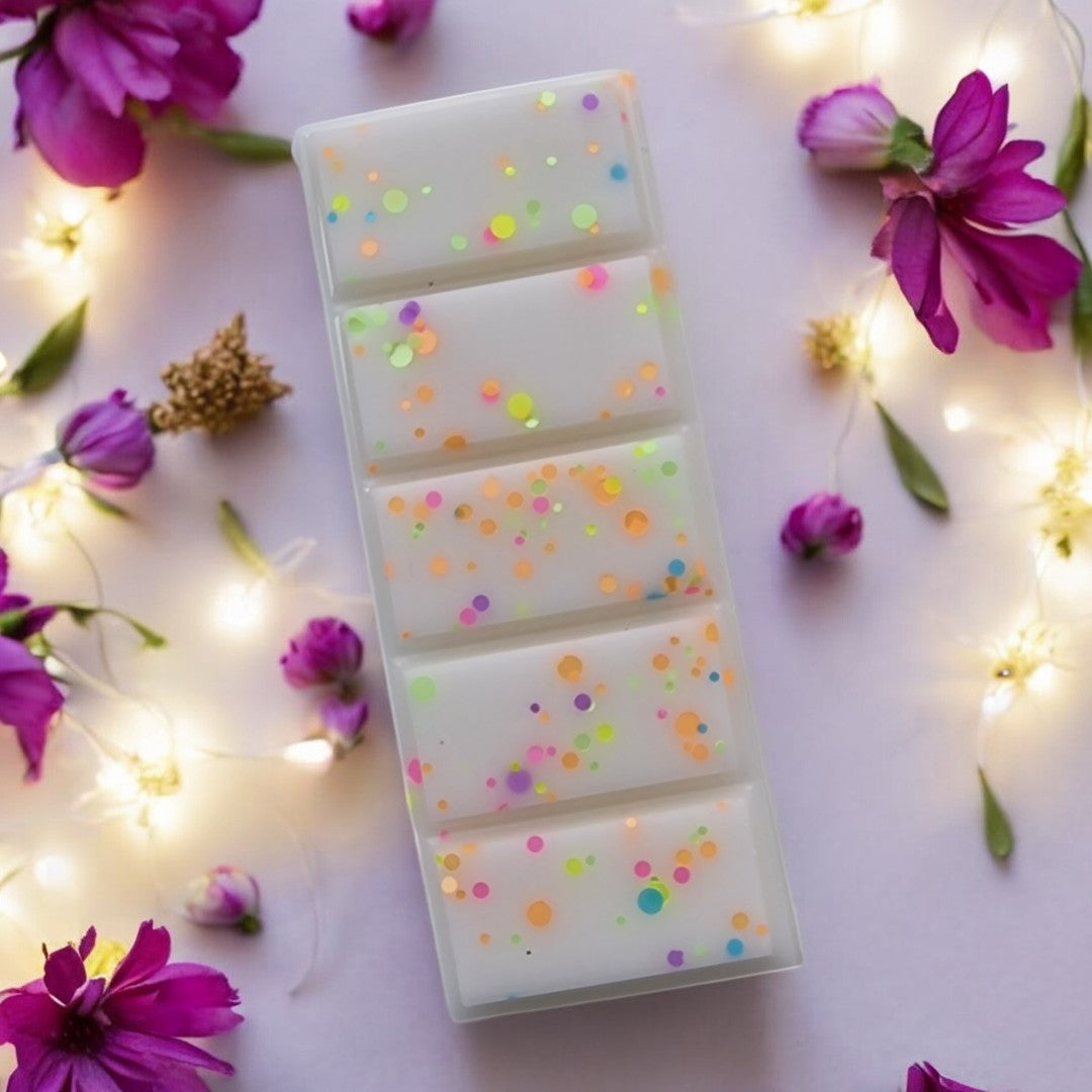 a close up of Floral Explosion Wax melt by Touch of class.  The wax melt is in the shape of a snap bar