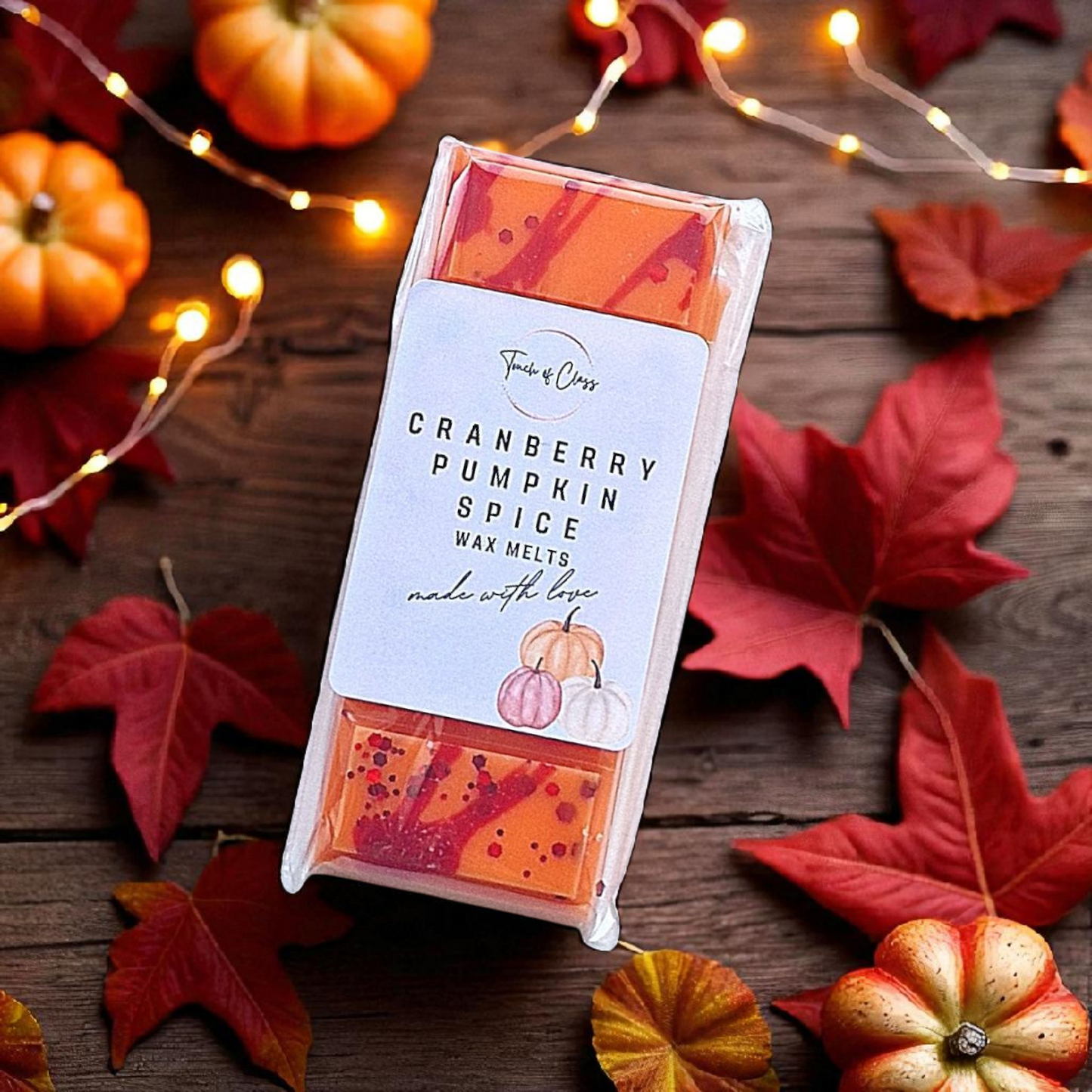 Cranberry Pumpkin Spice wax melts with autumn-themed decorations on a wooden surface.
