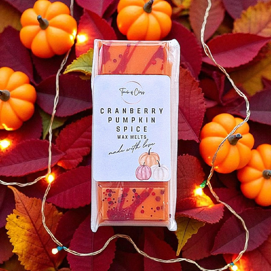 Cranberry Pumpkin Spice wax melts surrounded by pumpkins and leaves with string lights.
